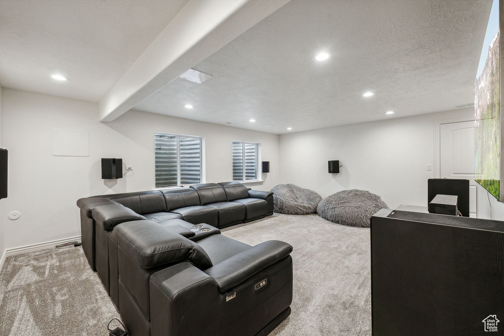 Living room with a textured ceiling, beamed ceiling, and light carpet