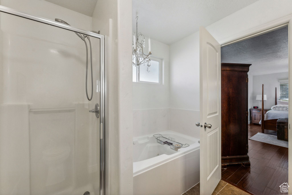 Bathroom featuring a chandelier, hardwood / wood-style floors, and separate shower and tub