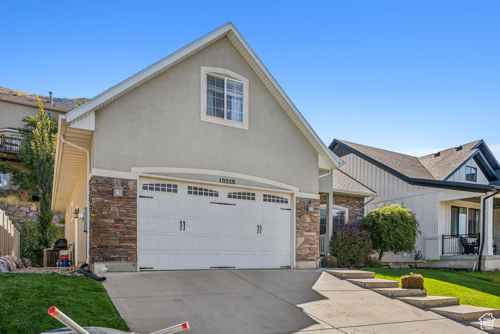 View of front of house featuring a front yard and a garage