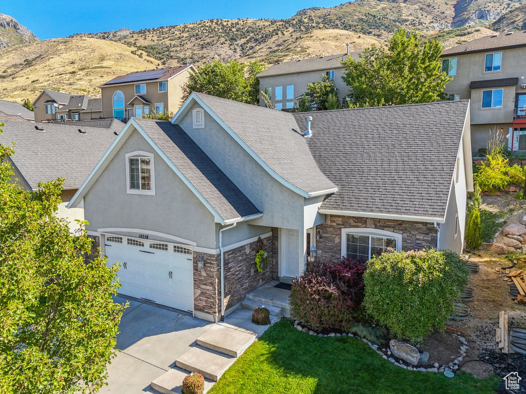 View of front of home with a mountain view and a garage