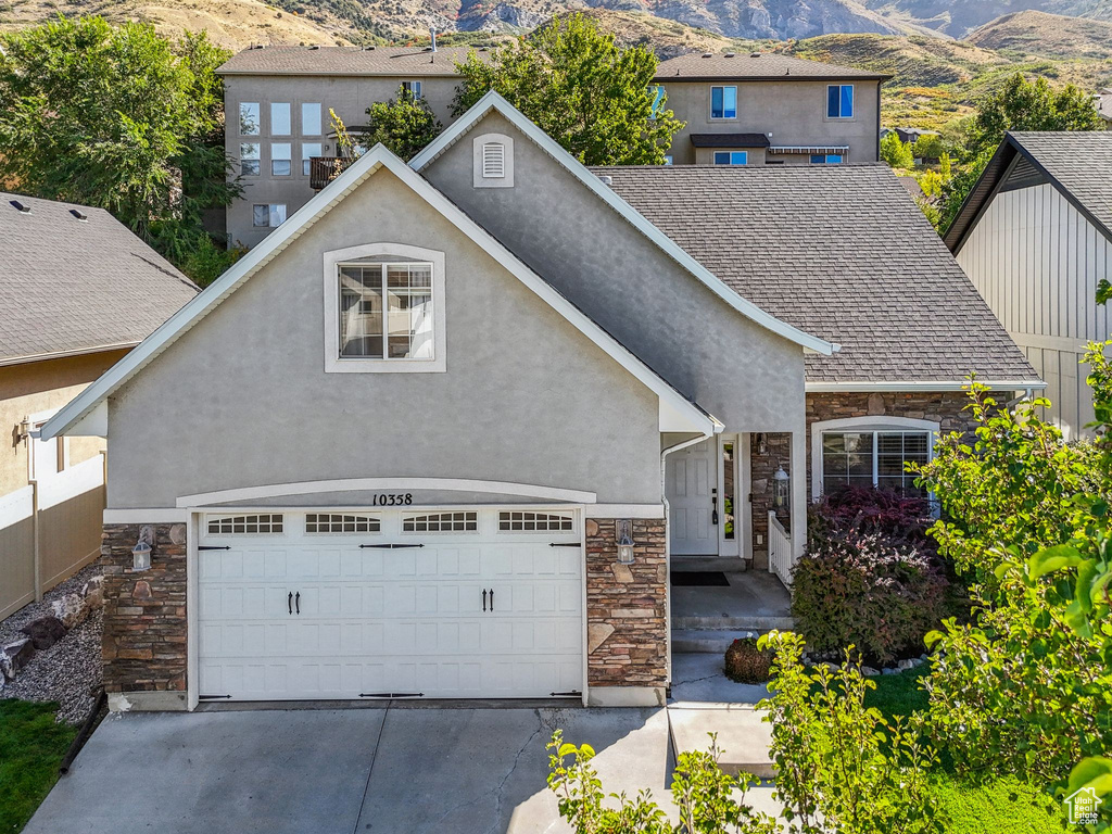 View of front of home with a mountain view and a garage