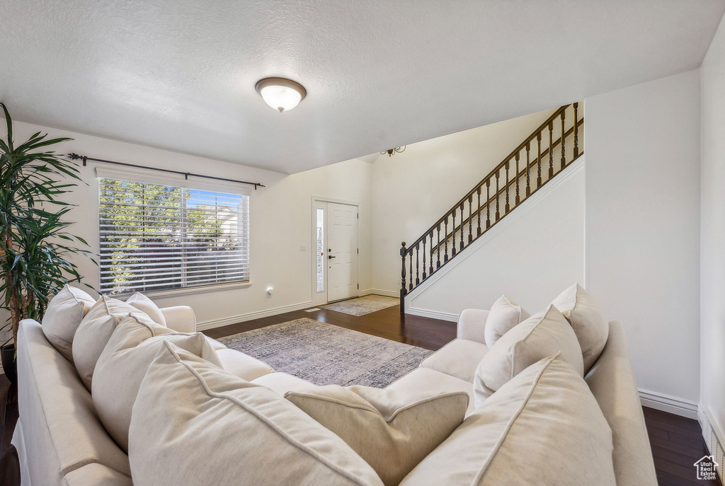 Living room with a textured ceiling and dark hardwood / wood-style floors