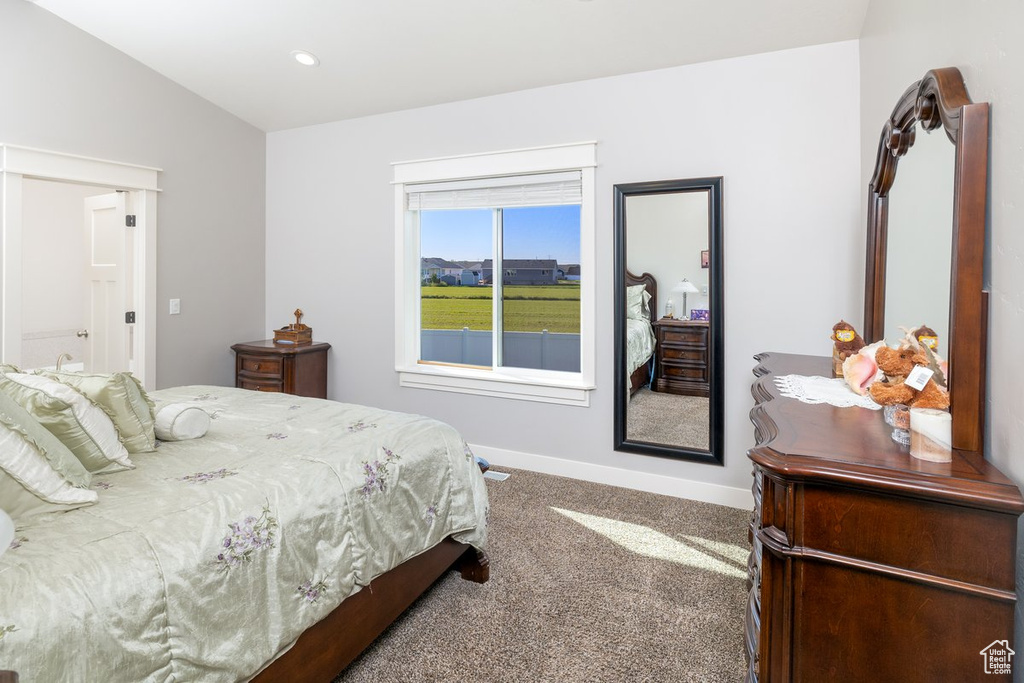 Carpeted bedroom featuring vaulted ceiling