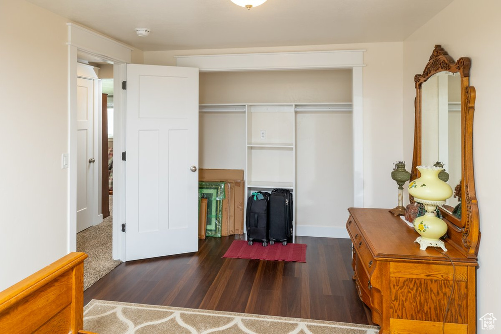 Bedroom featuring dark hardwood / wood-style flooring and a closet