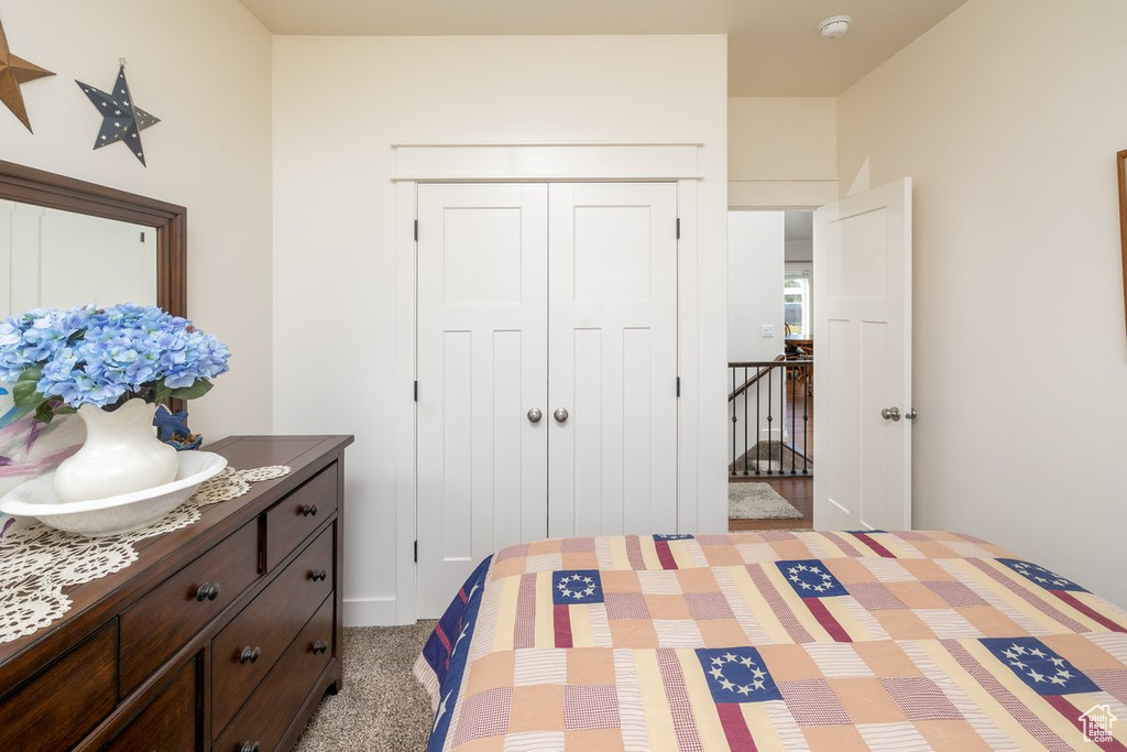 Bedroom with light carpet and a closet