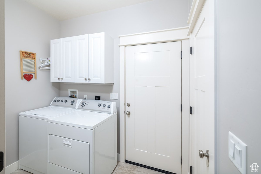 Laundry area with separate washer and dryer and cabinets