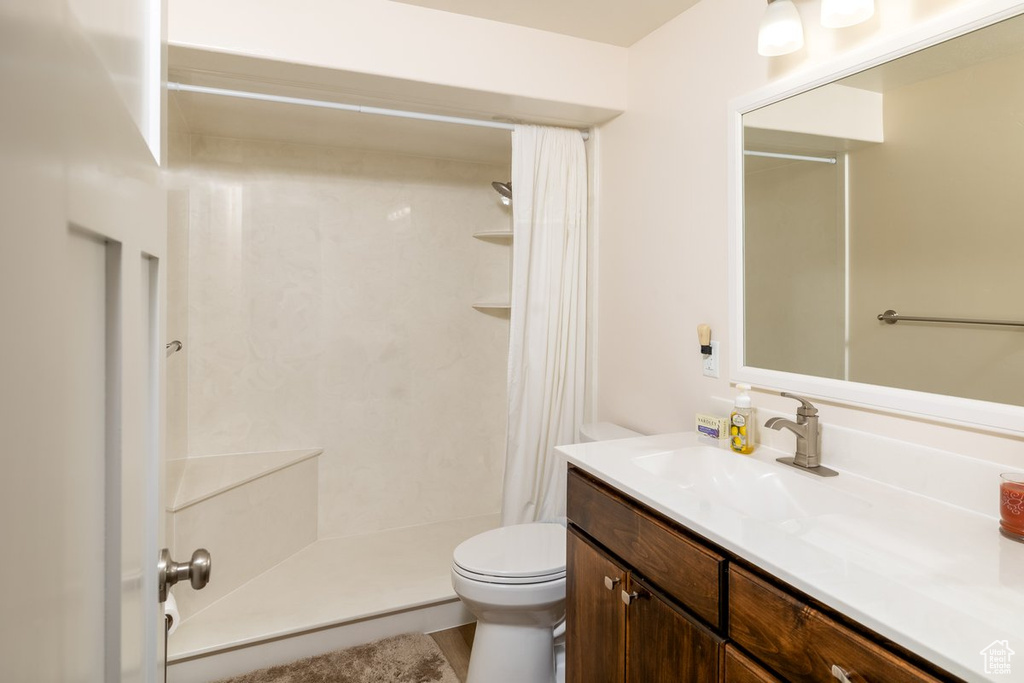 Bathroom with a shower with curtain, vanity, and toilet