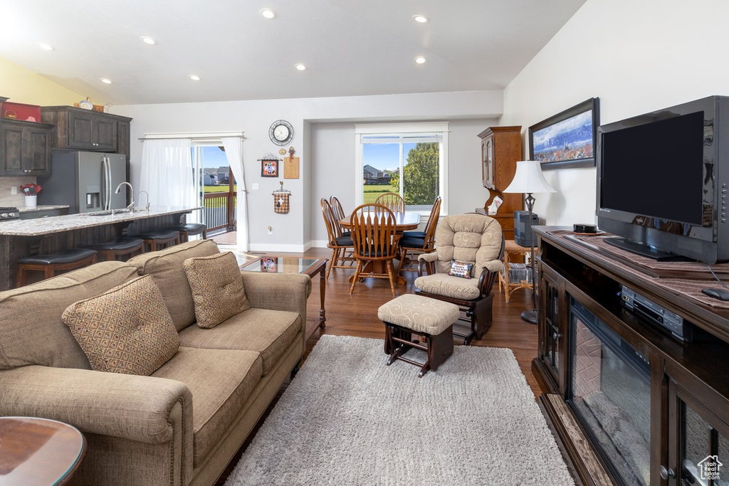 Living room featuring vaulted ceiling, dark hardwood / wood-style flooring, and sink