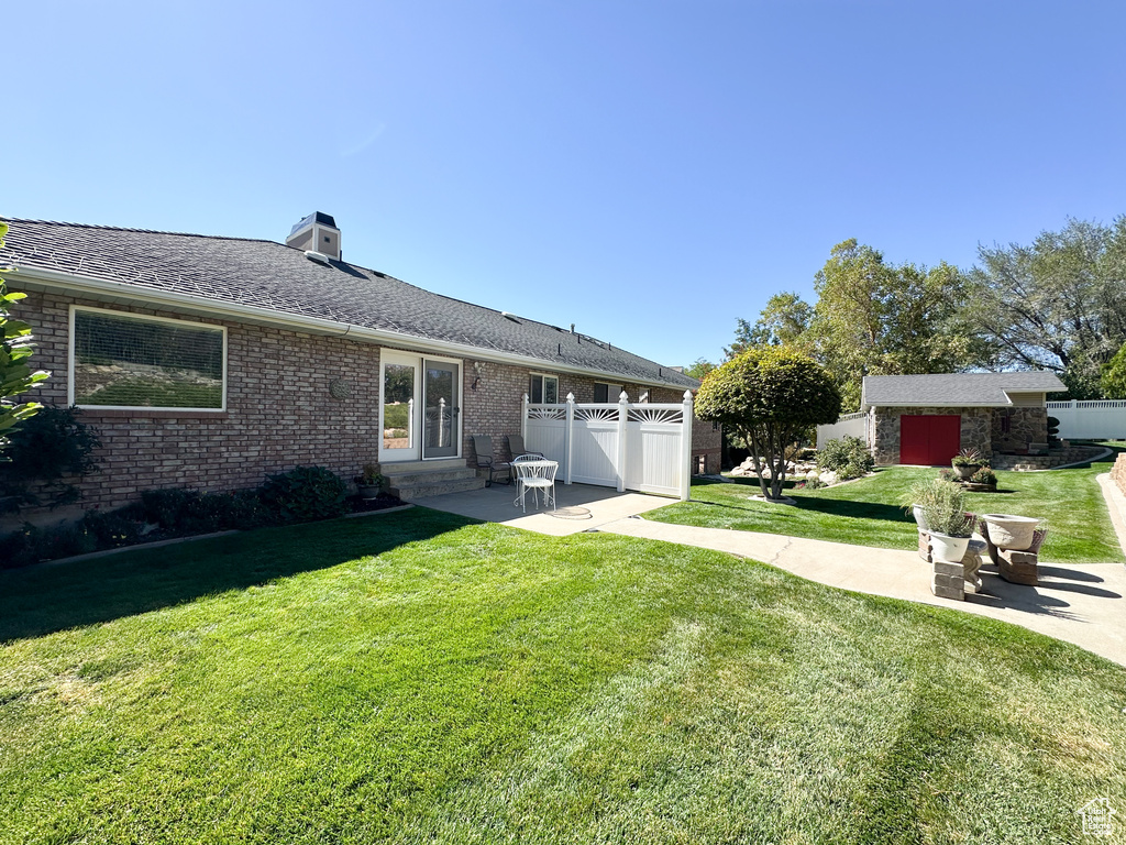 Back of house with a yard and a patio area