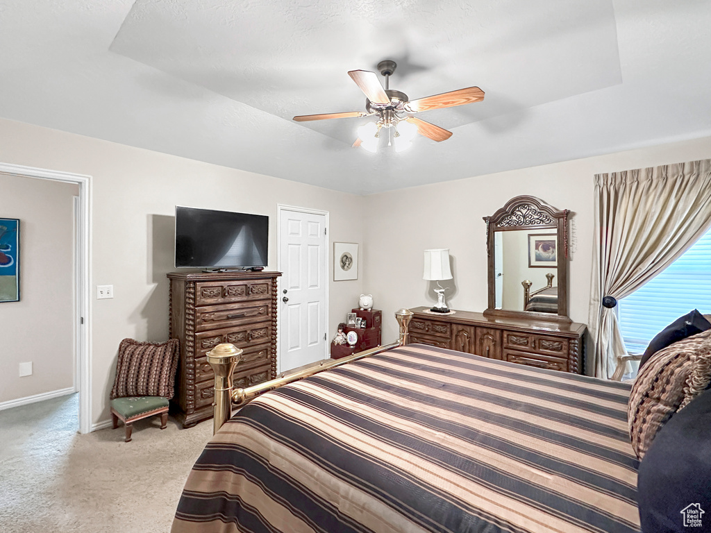 Bedroom with ceiling fan and light colored carpet