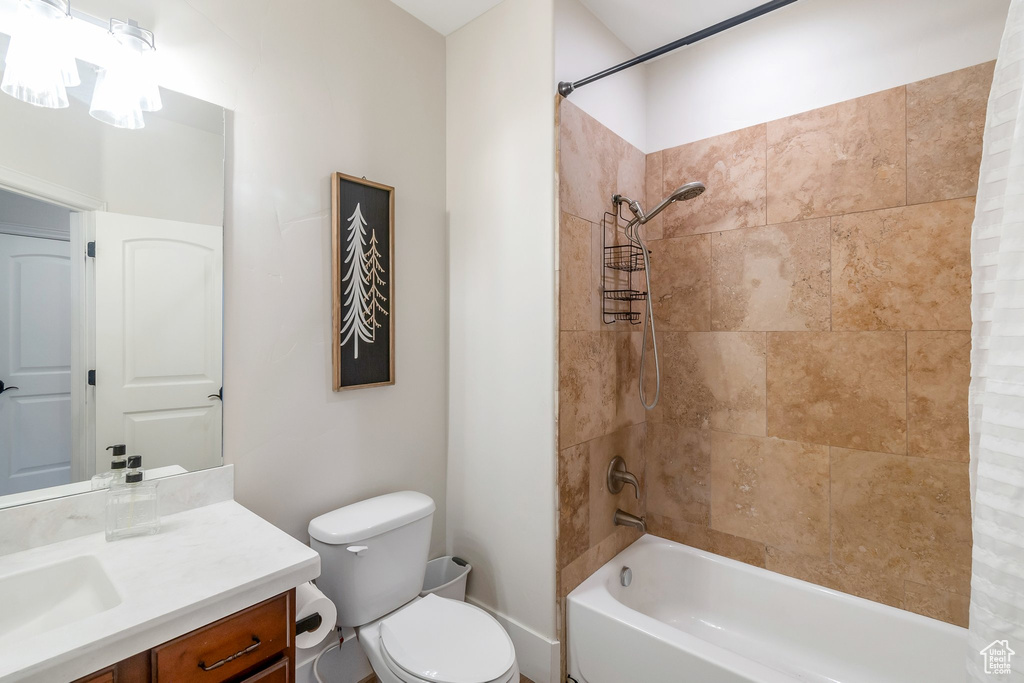 Full bathroom featuring shower / tub combo with curtain, vanity, and toilet