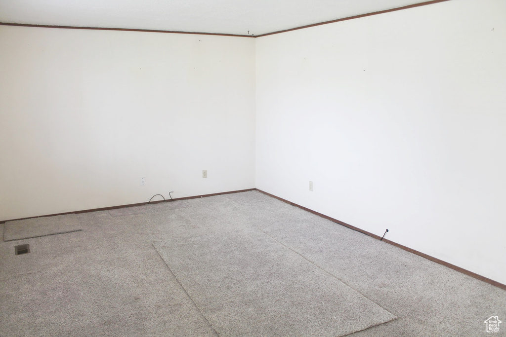 Carpeted empty room featuring baseboards