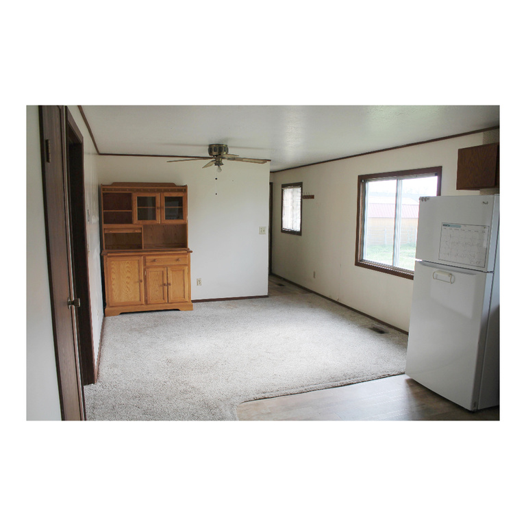 Unfurnished living room featuring ceiling fan