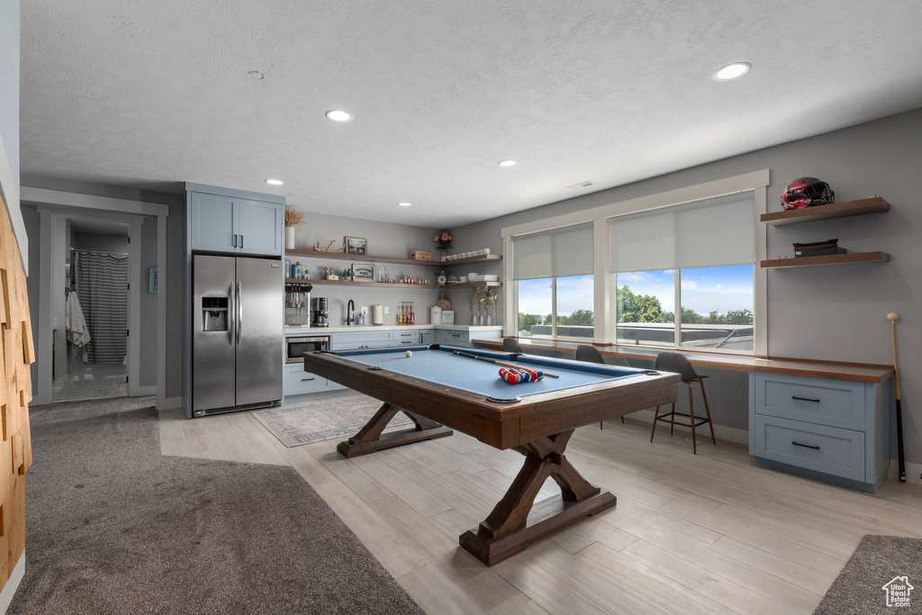 Rec room featuring built in desk, a textured ceiling, light hardwood / wood-style flooring, pool table, and sink