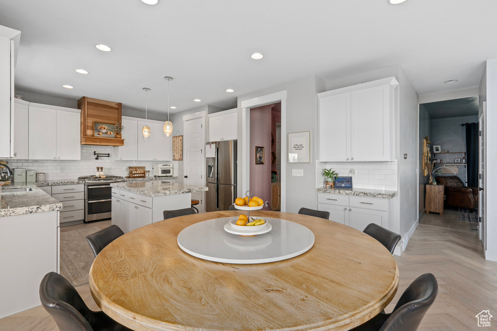 Dining space with light parquet floors and sink