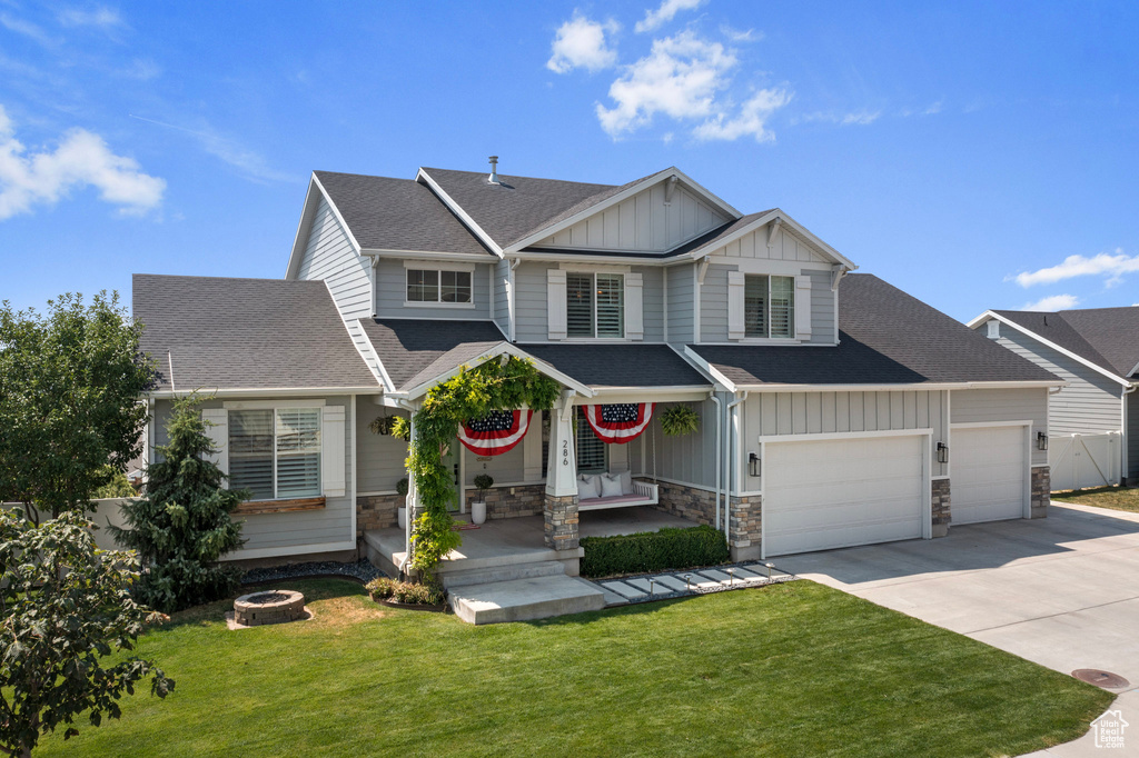 Craftsman-style house featuring a porch, a garage, and a front lawn