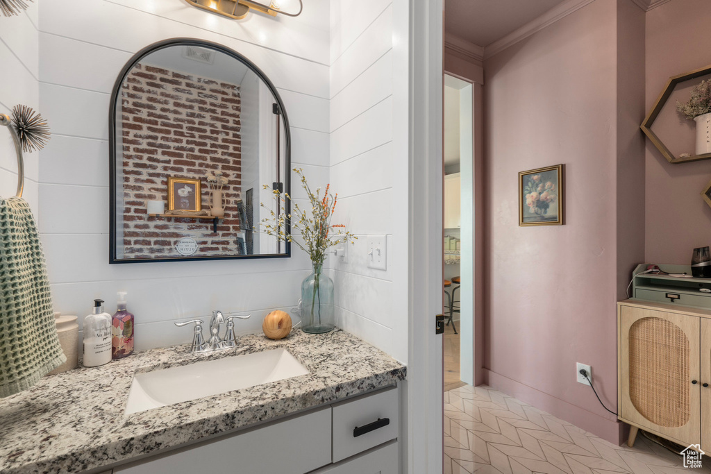 Bathroom with ornamental molding and vanity