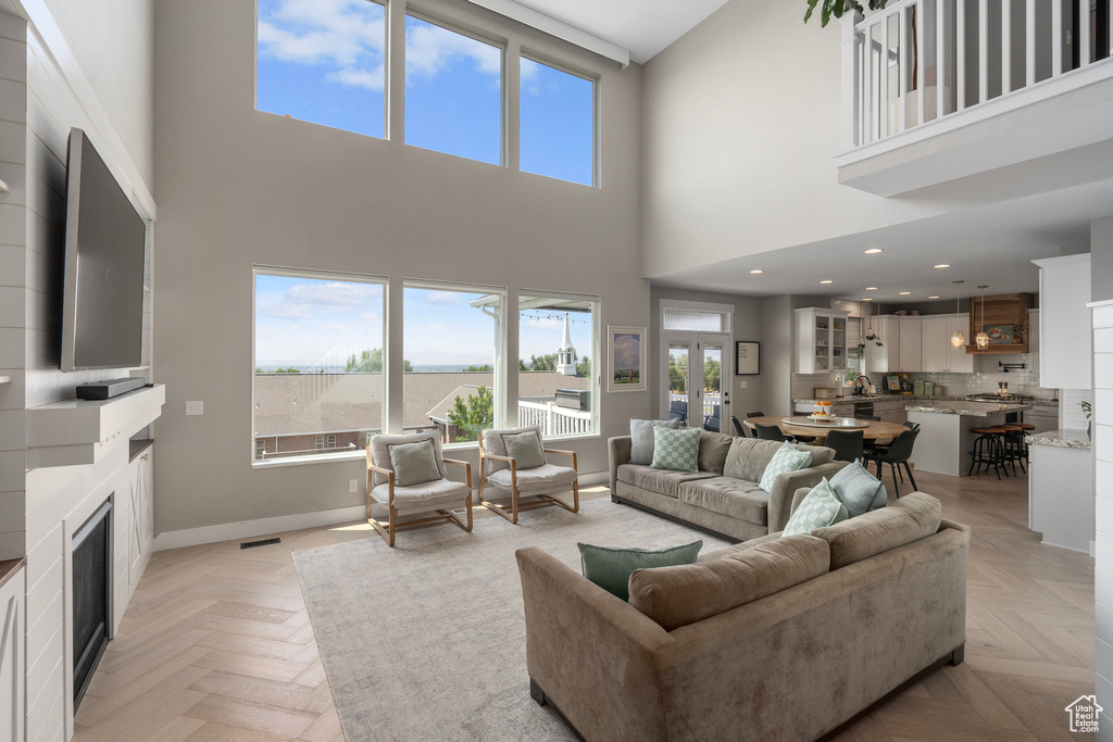 Living room featuring a high ceiling and light parquet floors