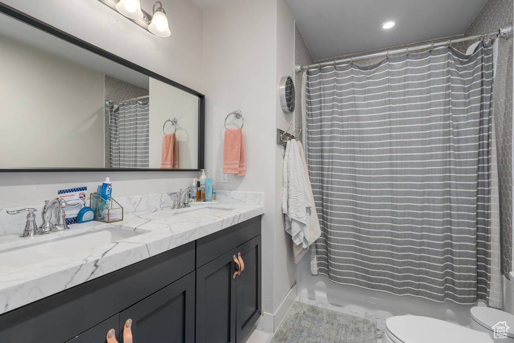 Full bathroom with shower / tub combo with curtain, vanity, and toilet