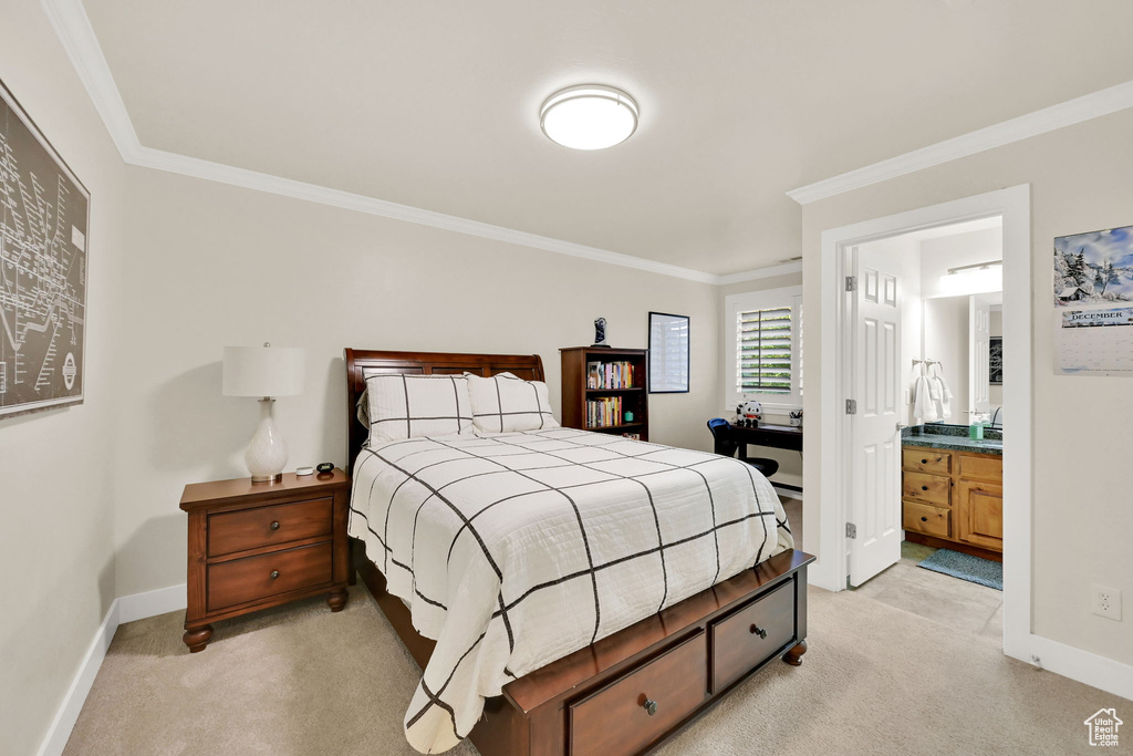 Carpeted bedroom with ornamental molding and ensuite bathroom