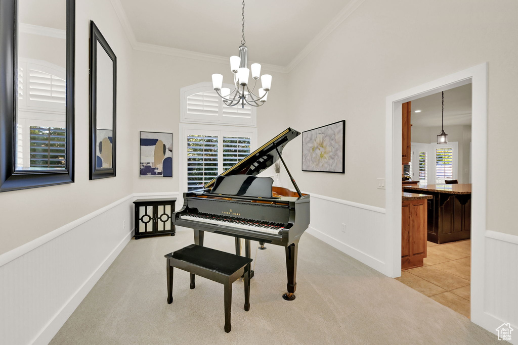 Miscellaneous room with ornamental molding, an inviting chandelier, and light colored carpet