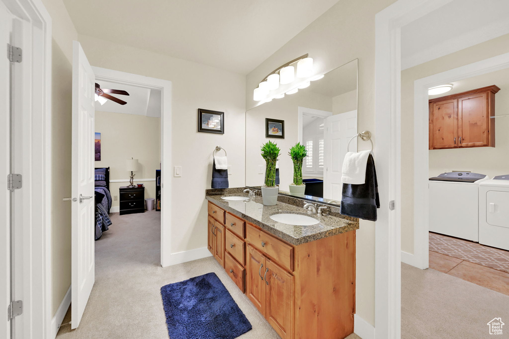 Bathroom with washer and clothes dryer, vanity, ceiling fan, and tile patterned floors