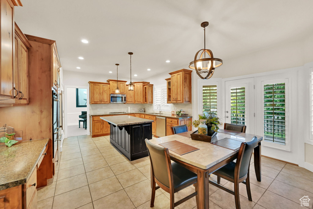 Tiled dining space featuring an inviting chandelier and sink