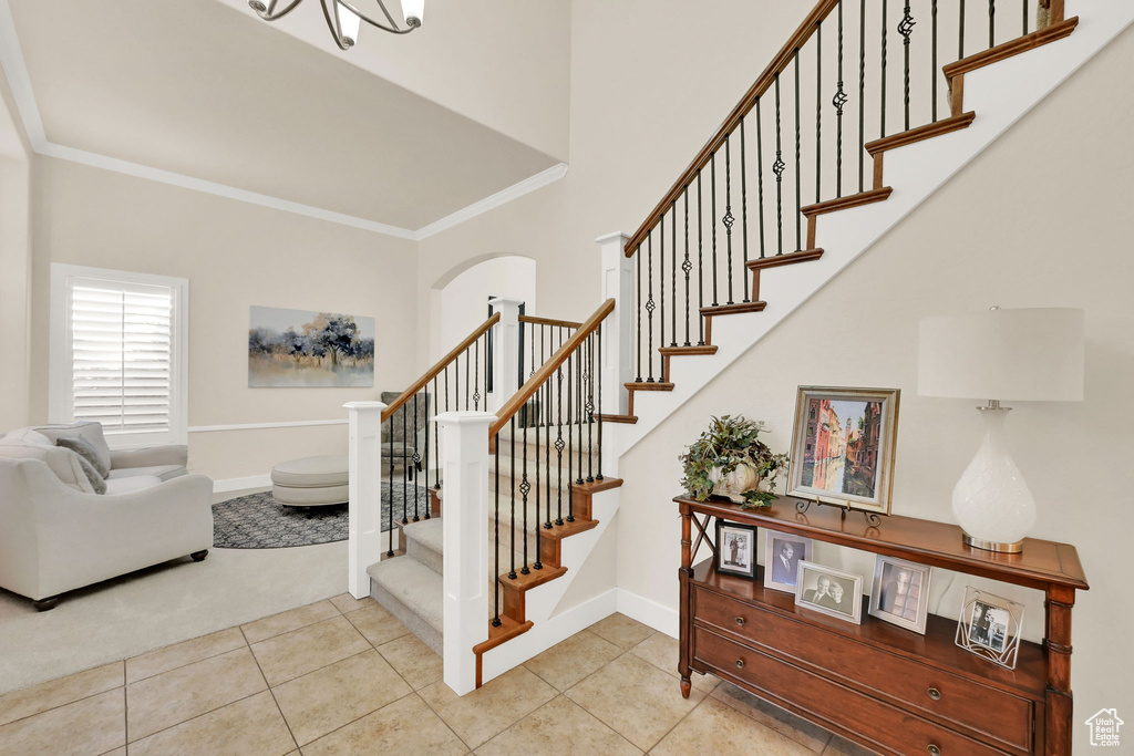 Staircase with ornamental molding and tile patterned floors