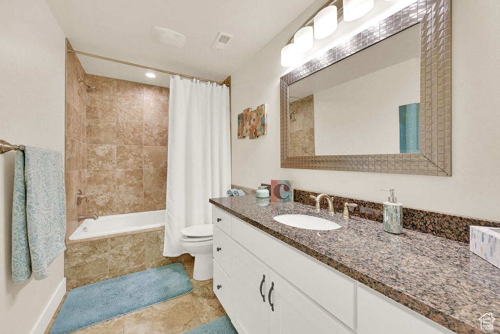 Full bathroom with shower / tub combo with curtain, vanity, and toilet