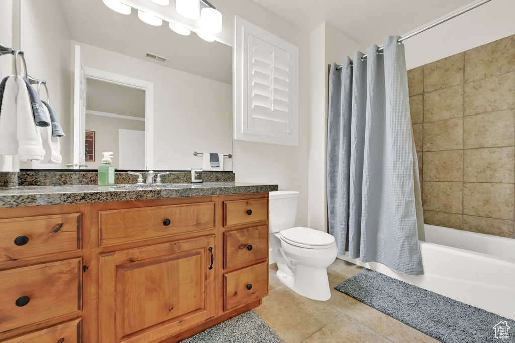 Full bathroom with shower / tub combo, tile patterned flooring, vanity, and toilet