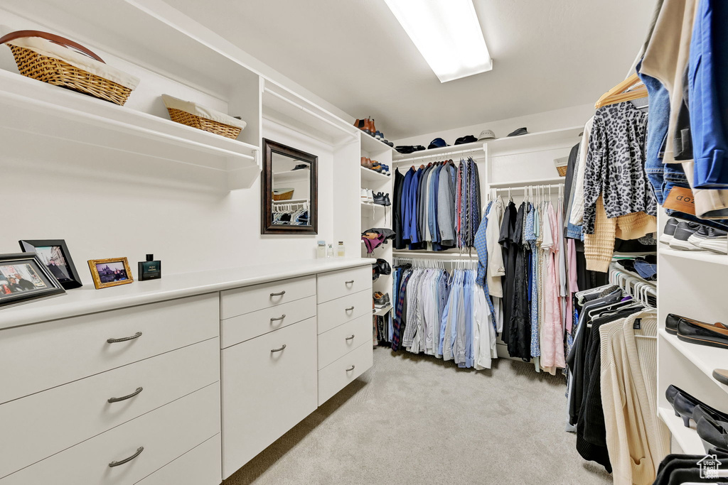 Walk in closet with light colored carpet