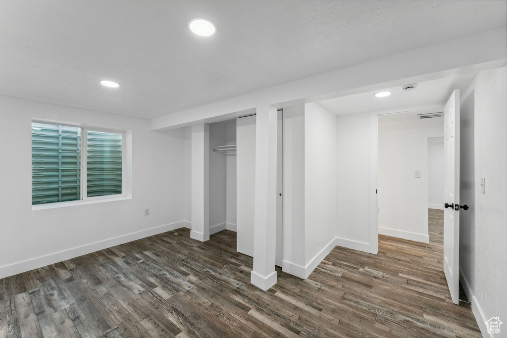 Unfurnished bedroom with dark wood-type flooring