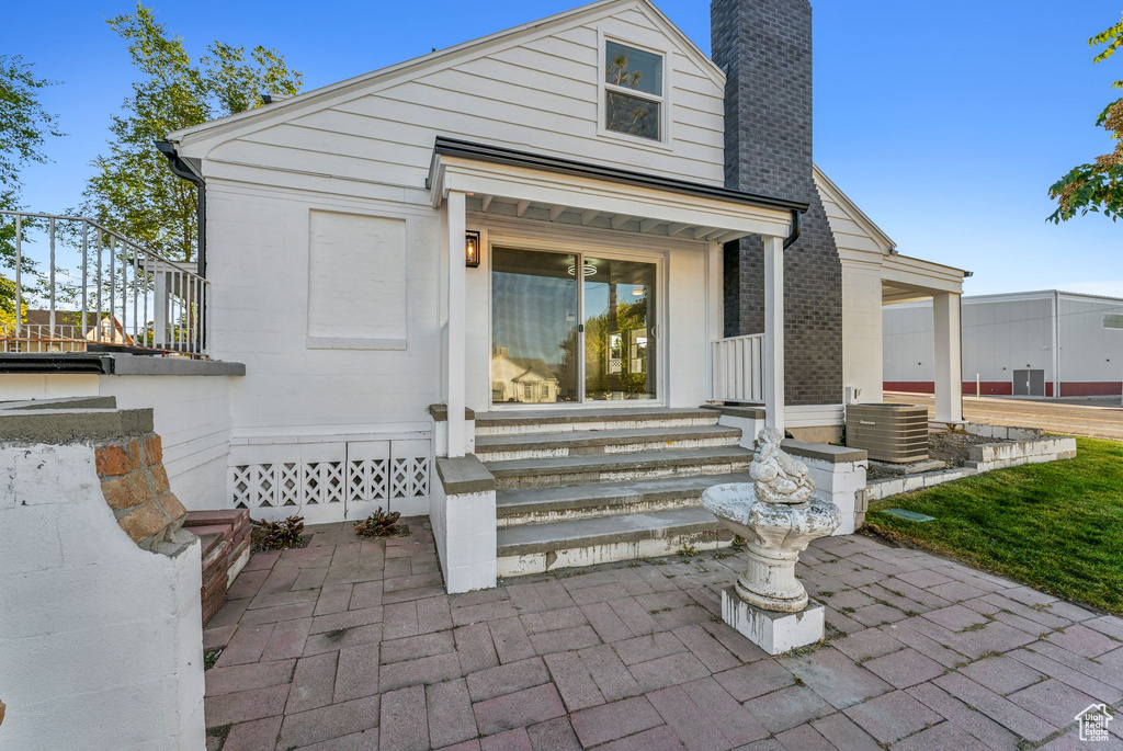 Entrance to property featuring central AC unit and a patio area