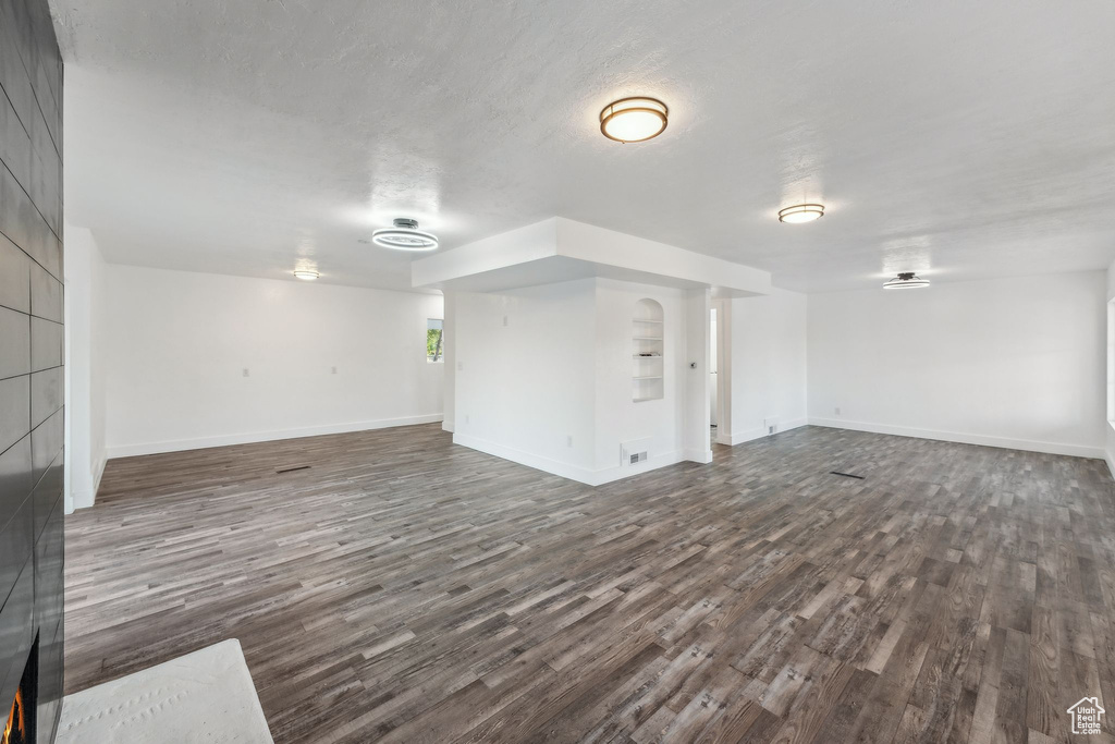 Unfurnished living room featuring dark hardwood / wood-style flooring