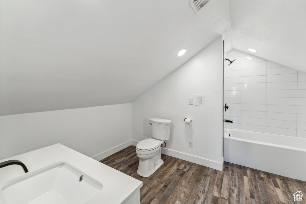 Full bathroom with shower / tub combination, lofted ceiling, toilet, and hardwood / wood-style flooring