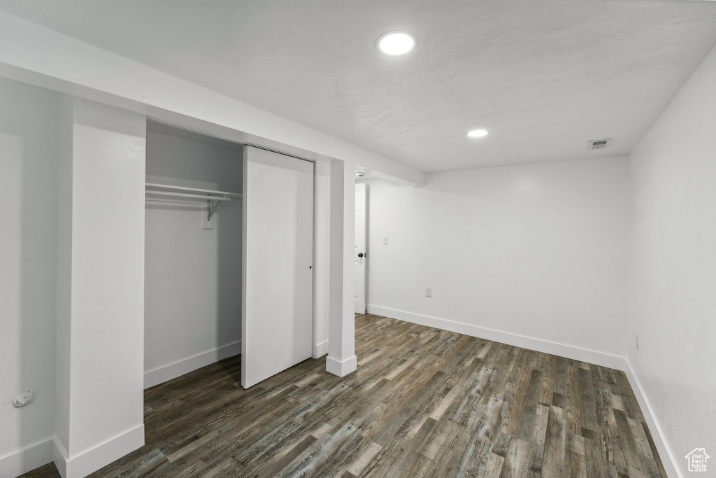 Unfurnished bedroom featuring a closet and dark hardwood / wood-style flooring