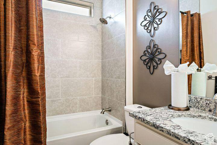 Full bathroom featuring vanity, shower / tub combo, and toilet