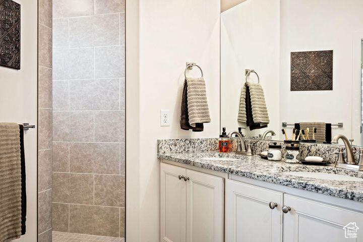 Bathroom with vanity and tiled shower