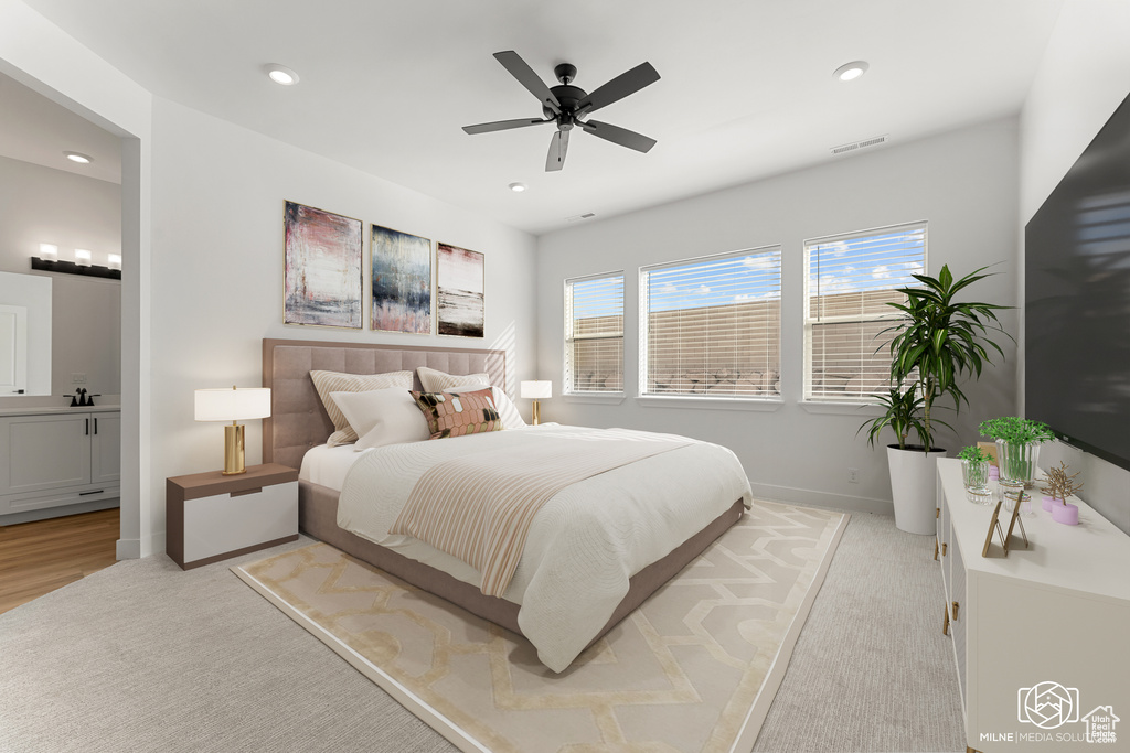 Carpeted bedroom featuring ceiling fan and ensuite bath