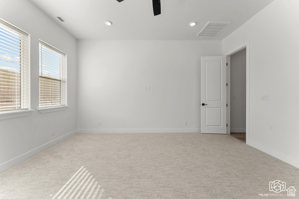 Unfurnished room featuring light colored carpet and ceiling fan