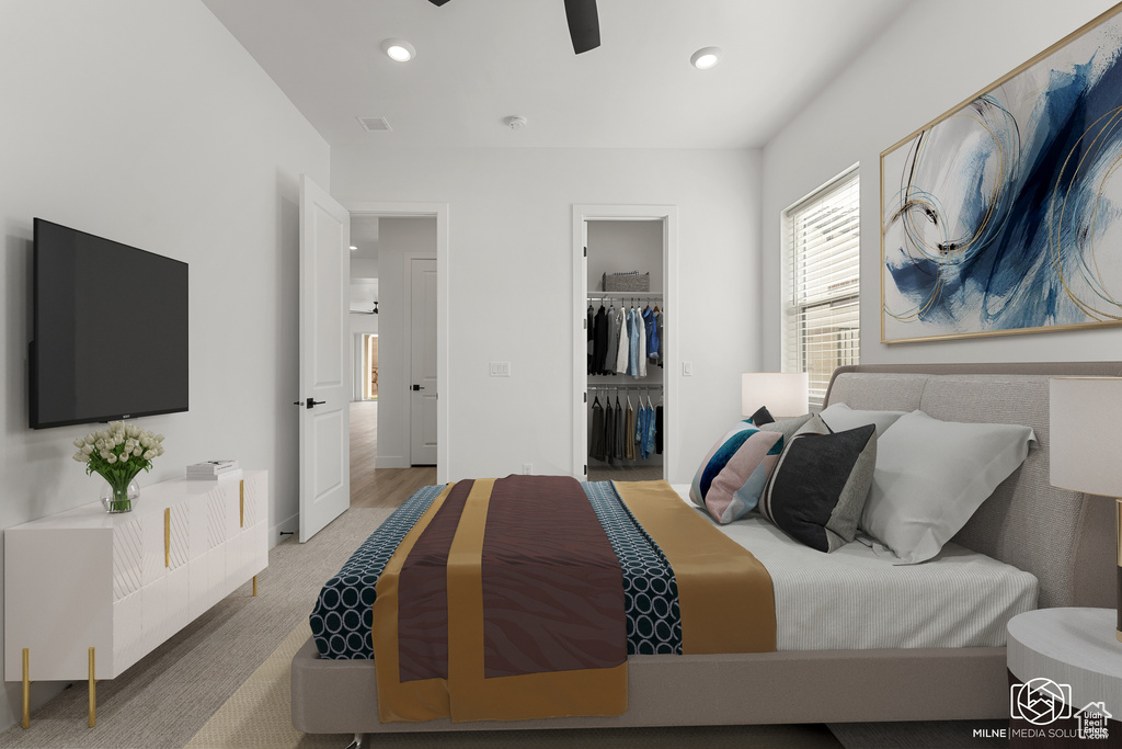 Carpeted bedroom featuring a spacious closet, a closet, and ceiling fan