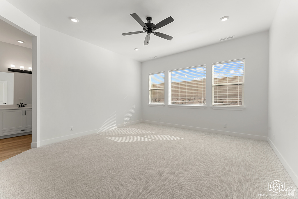 Spare room with light colored carpet and ceiling fan