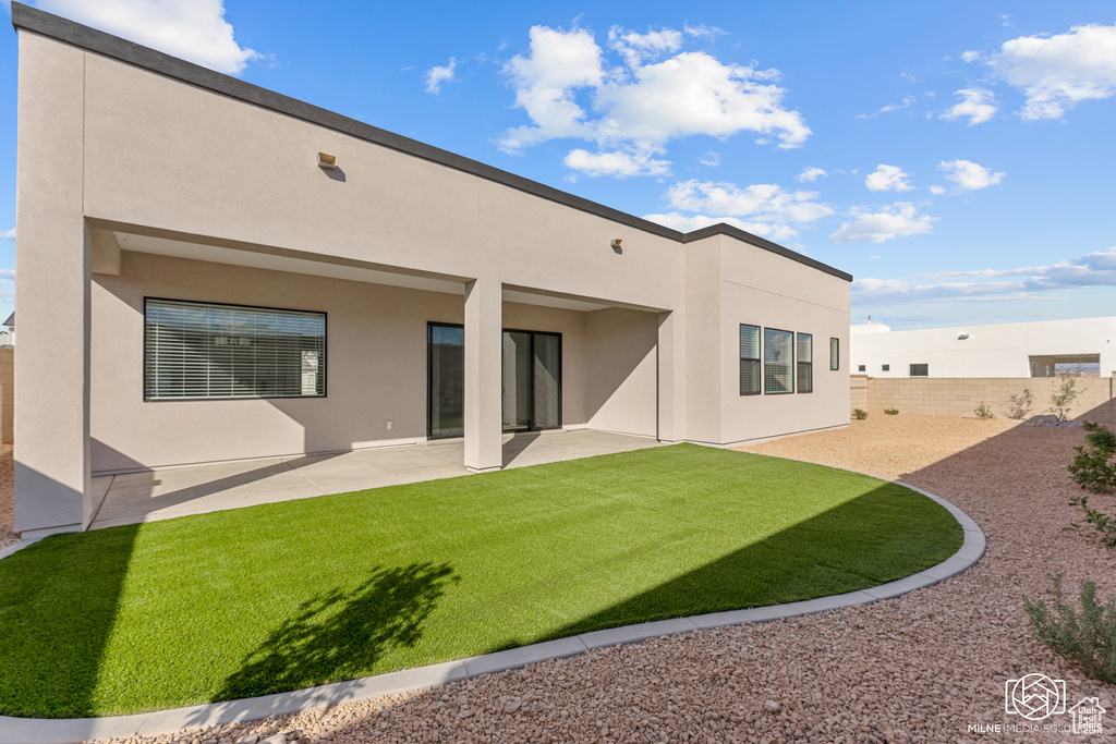 Rear view of property with a patio area and a lawn