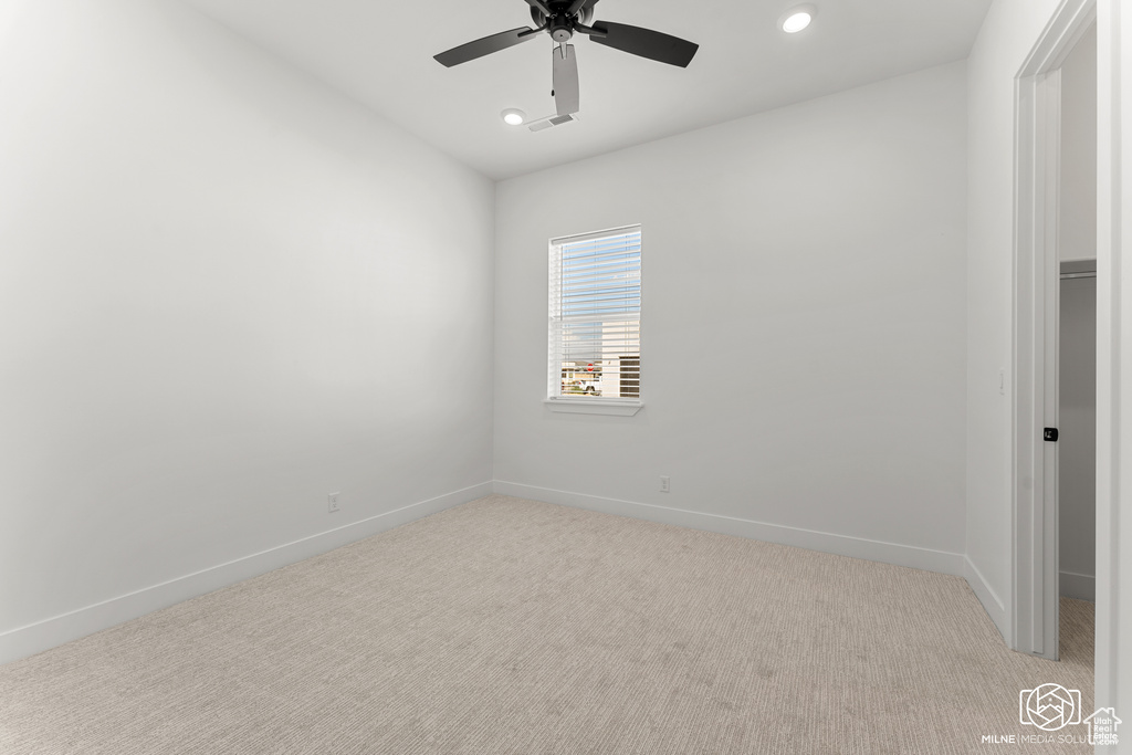 Carpeted spare room with ceiling fan