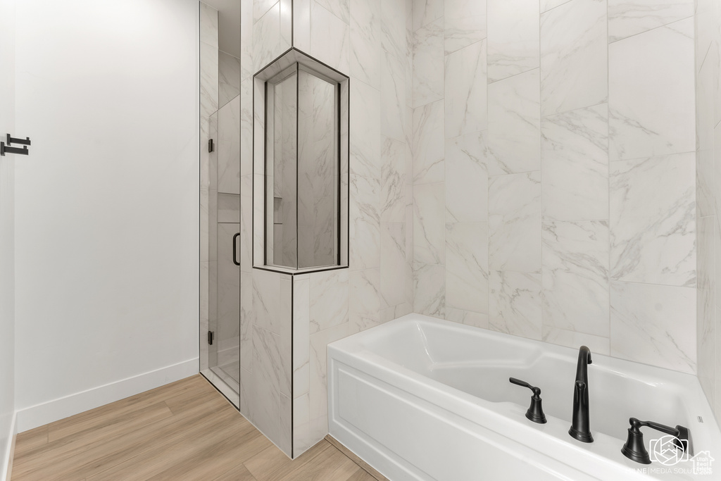 Bathroom featuring hardwood / wood-style floors and separate shower and tub