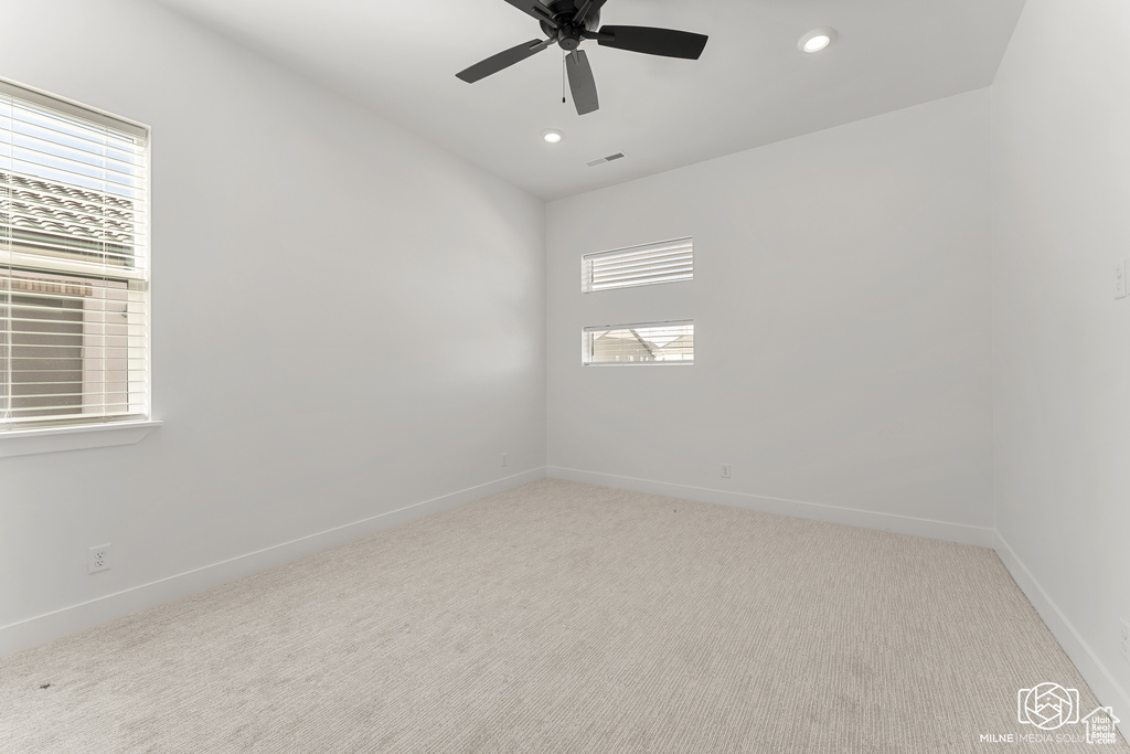 Unfurnished room featuring ceiling fan and light colored carpet