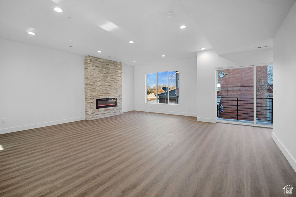 Unfurnished living room featuring wood-type flooring and a fireplace