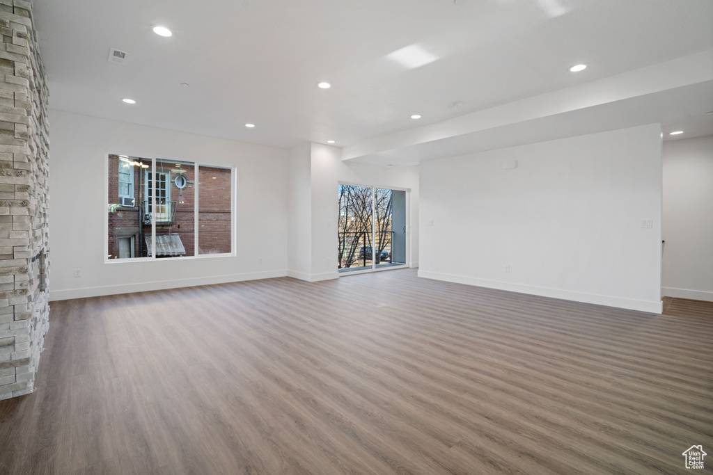 Unfurnished living room with dark wood-type flooring