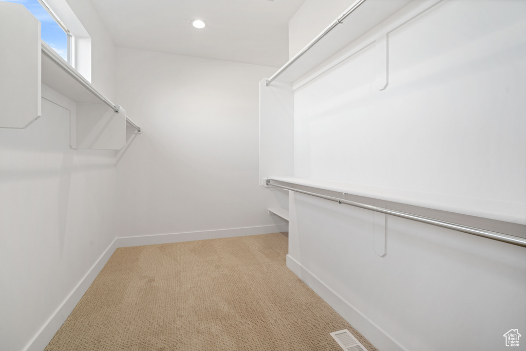 Walk in closet with light carpet