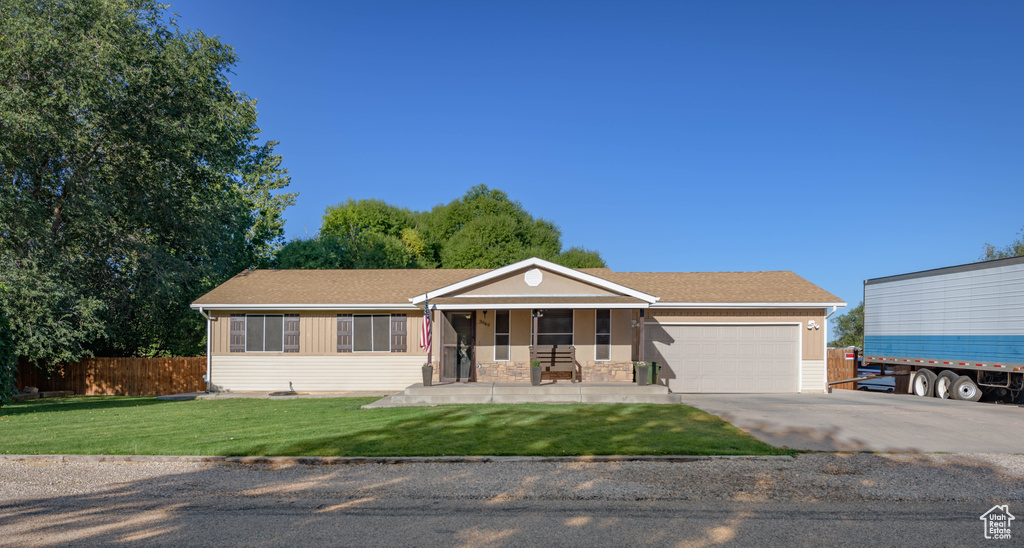 View of front facade with a front lawn, covered porch, and a garage